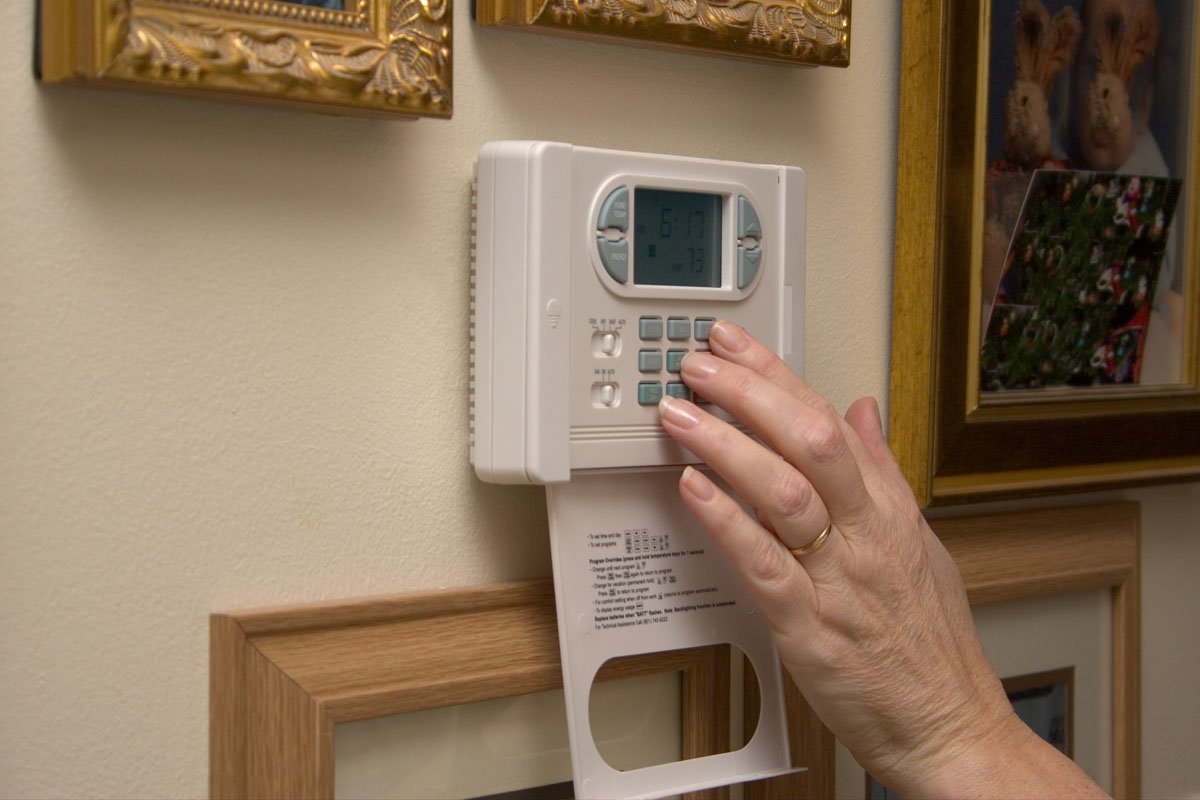 A homeowner inspecting a noisy aging boiler in the basement of a greater Binghamton NY home during a cold Southern Tier winter