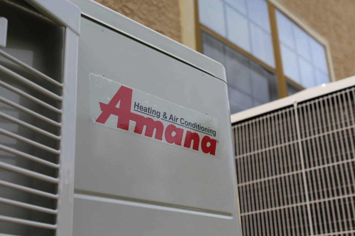 HVAC technician inspecting an older gas furnace in a Binghamton NY home basement during a spring heating system evaluation