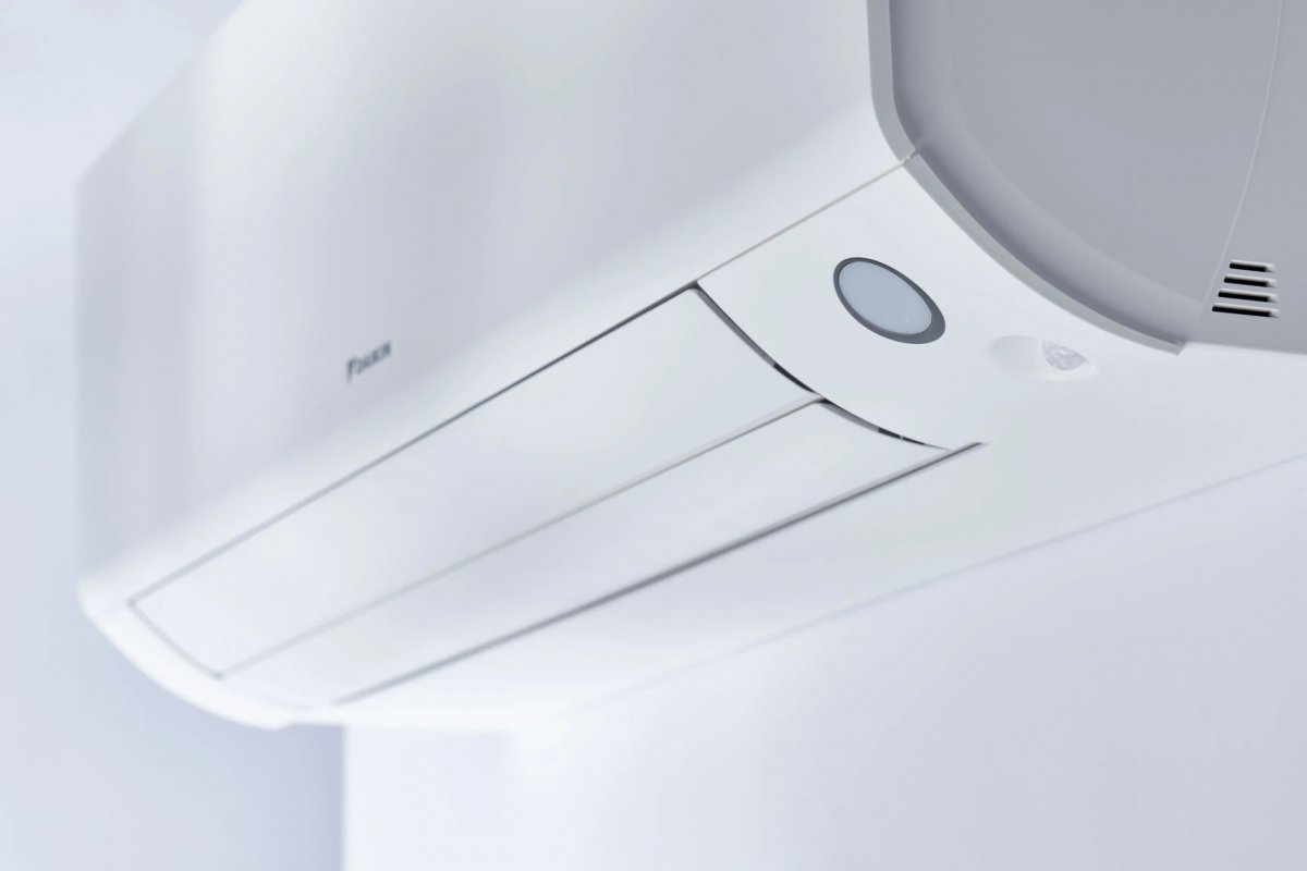 HVAC technician measuring a living room to calculate proper air conditioner sizing for a Binghamton NY home during a spring installation consultation