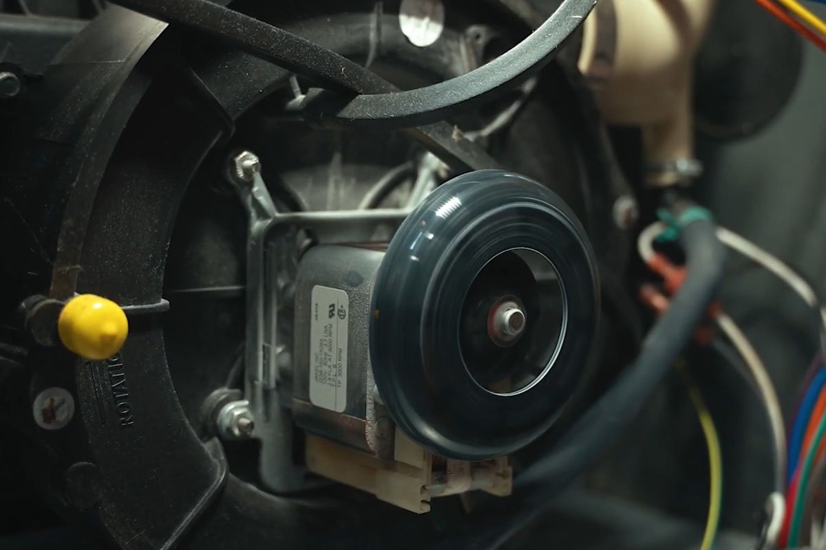 An HVAC technician performing a spring AC tune-up on a central air conditioning unit outside a greater Binghamton NY home