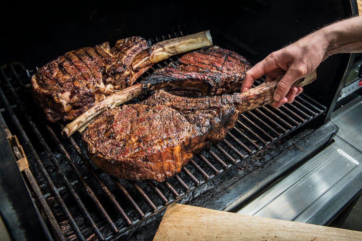 A Traeger wood pellet grill producing blue smoke in a Binghamton NY backyard during a cold Southern Tier winter day